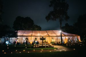 Wedding Ceremony from Outside lit with a candlelit path and fountatin in front of the wedding tent